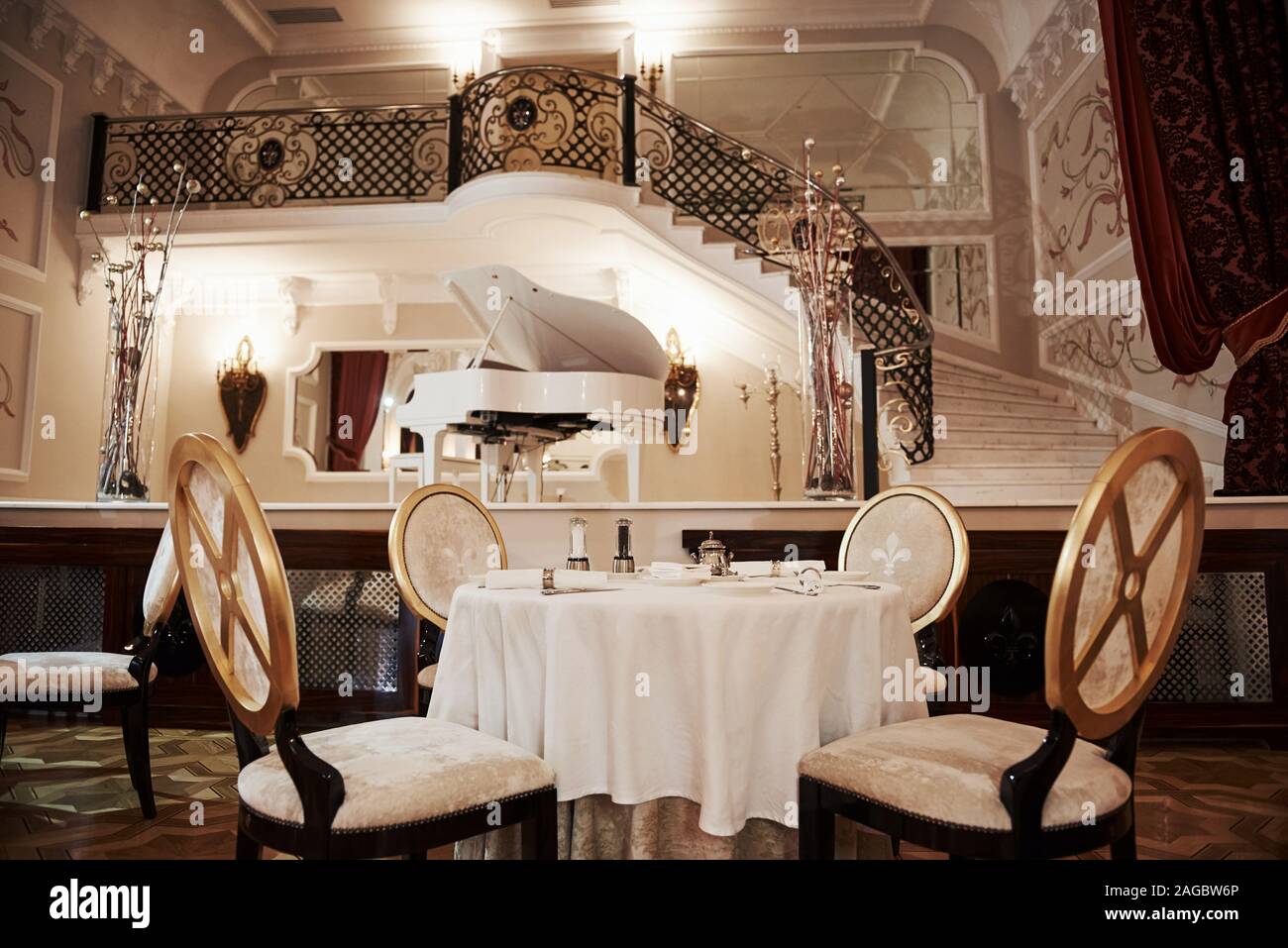Le tableau pour les quatre personnes est prêt à recevoir des visiteurs.  Intérieur du restaurant de luxe dans vintage style aristocratique avec piano  sur la scène Photo Stock - Alamy