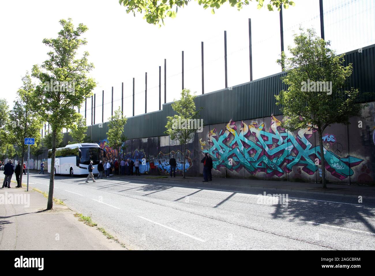 Les touristes visitant la murales colorées et graffiti sur le mur de la paix, ou la paix, le long de la ligne de Cupar Way à Belfast. Il est l'un des nombreux séparation Banque D'Images