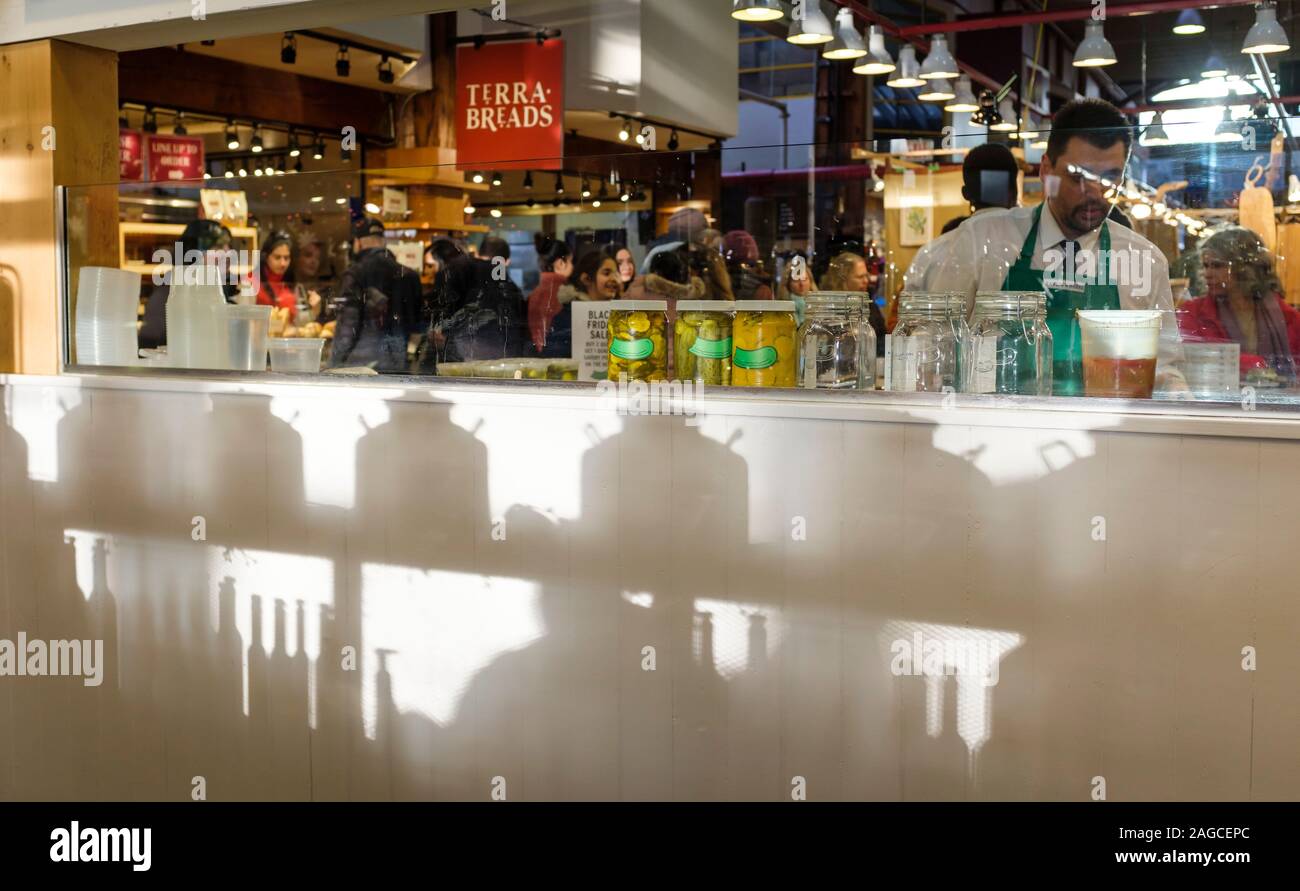 La fin de l'après-midi la lumière filtre à travers les pots et produit affiche au marché public de Granville Island à Vancouver (Colombie-Britannique) Banque D'Images