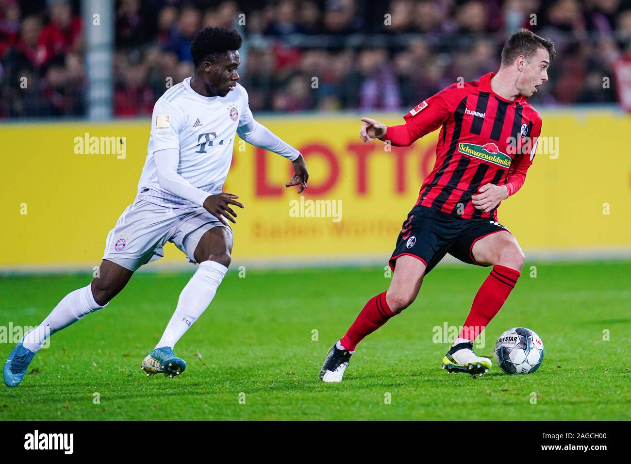 Freiburg im Breisgau, Allemagne. Dec 18, 2019. Soccer : Bundesliga, SC Freiburg - FC Bayern Munich, 16e journée dans le stade de la Forêt-Noire. Munich, Alphonso Davies (l) et Fribourg Janik Haberer lutte pour la balle. Credit : Uwe Anspach/DPA - NOTE IMPORTANTE : en conformité avec les exigences de la DFL Deutsche Fußball Liga ou la DFB Deutscher Fußball-Bund, il est interdit d'utiliser ou avoir utilisé des photographies prises dans le stade et/ou la correspondance dans la séquence sous forme d'images et/ou vidéo-comme des séquences de photos./dpa/Alamy Live News Banque D'Images