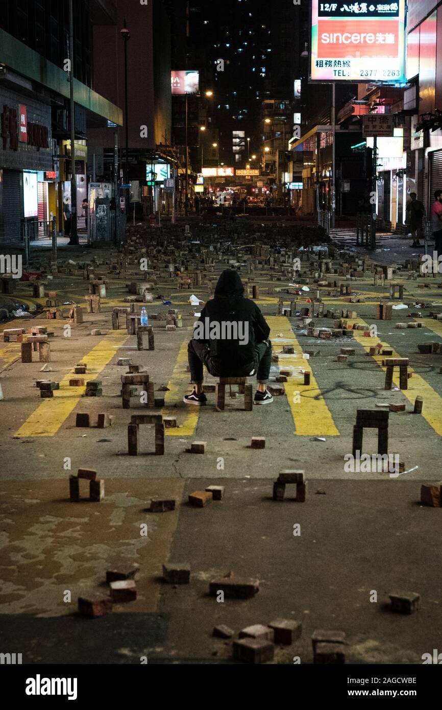 Novembre 2019 - HongKong, manifestant : assis sur barricade rue la nuit durant la HongKong 2019 protestations, une série de démonstrations à Hongkong Banque D'Images