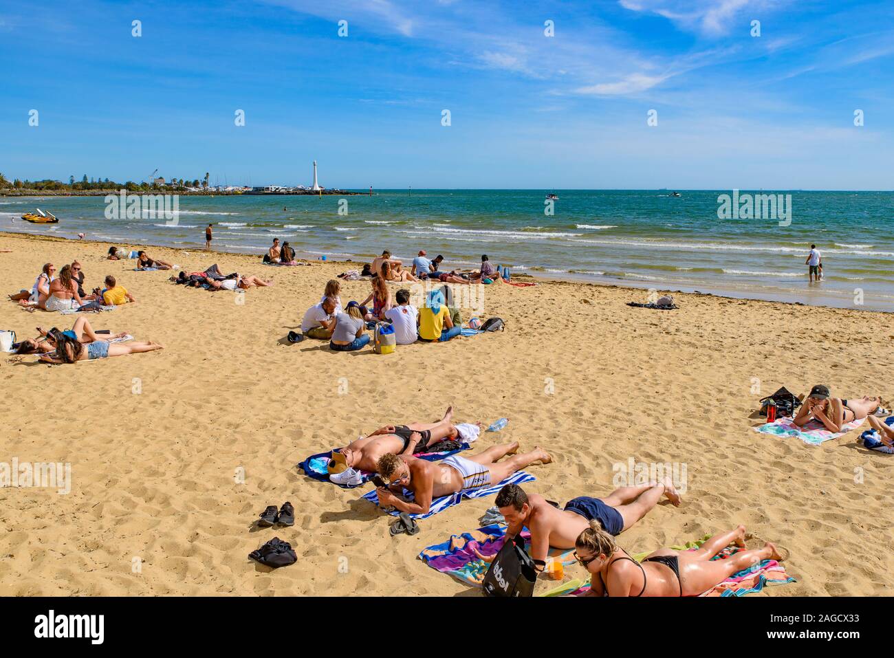 Les personnes bénéficiant de soleil à la plage St Kilda, la plage la plus célèbre de Melbourne, Australie Banque D'Images