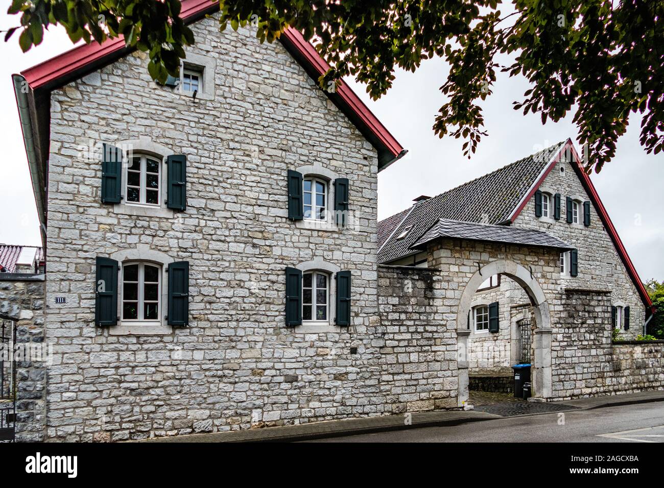 Manoir historique maison avec des volets verts, et porte d'entrée voûtée, construits dans les fondation en gris-blanc et de granit Belge, dans l'histo Banque D'Images