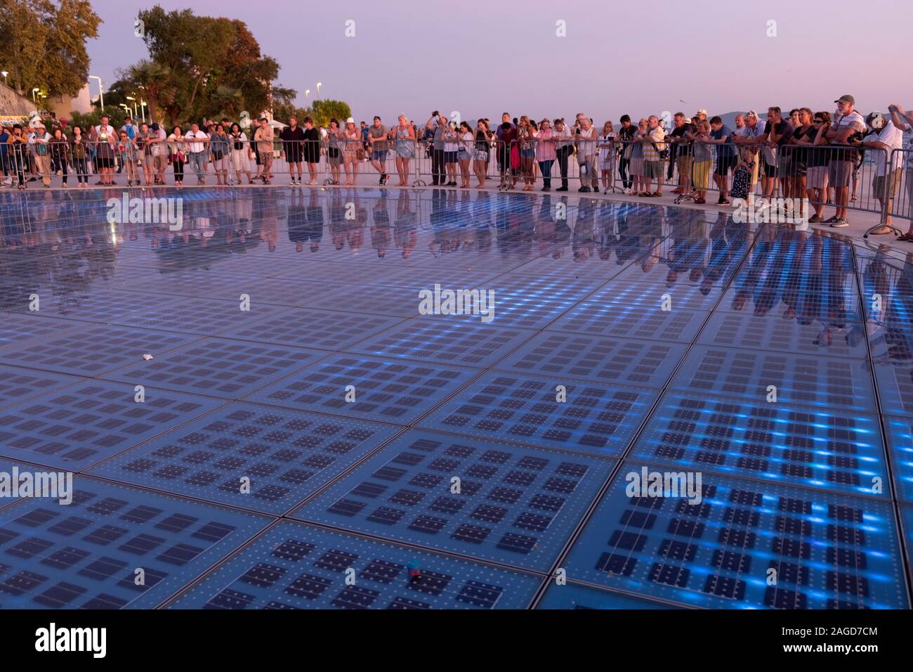 La foule à la salutation au soleil du port de Zadar par l'architecte Nikola Bašić qui recueille la lumière du soleil à l'alimentation de puissance et de montrer d'autres feux avant-port, Zadar, Banque D'Images