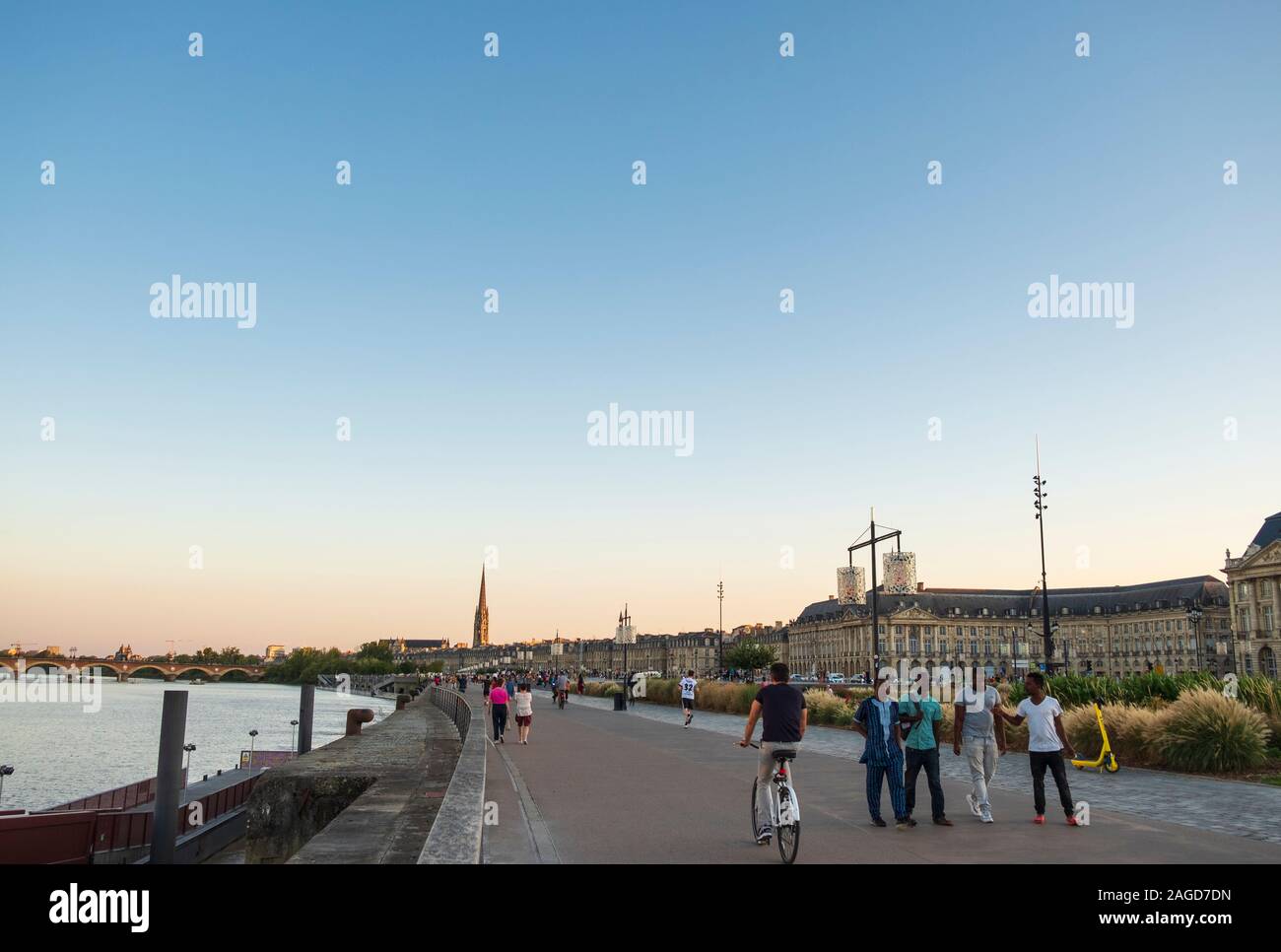 Promenade le long de la rivière Garrone auprès des marcheurs et cyclistes au coucher du soleil, la ville de Bordeaux, France Banque D'Images