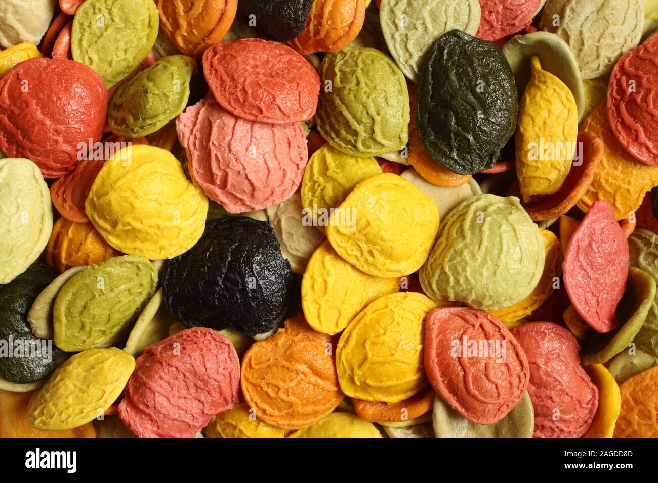 Arrière-plan de l'alimentation - semoule de blé dur coloré non cuit Pâtes Orecchiette avec l'ajout de la ingrédients spéciaux : carotte, betterave rouge, spina Banque D'Images