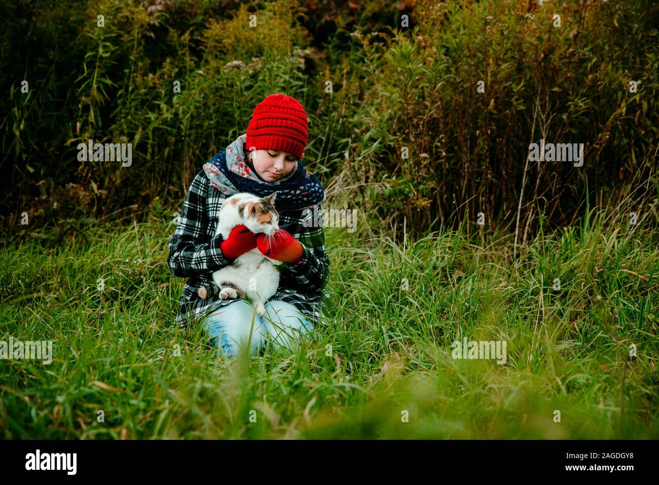 Jeune fille tenant son chat dehors par une froide journée d'octobre Banque D'Images