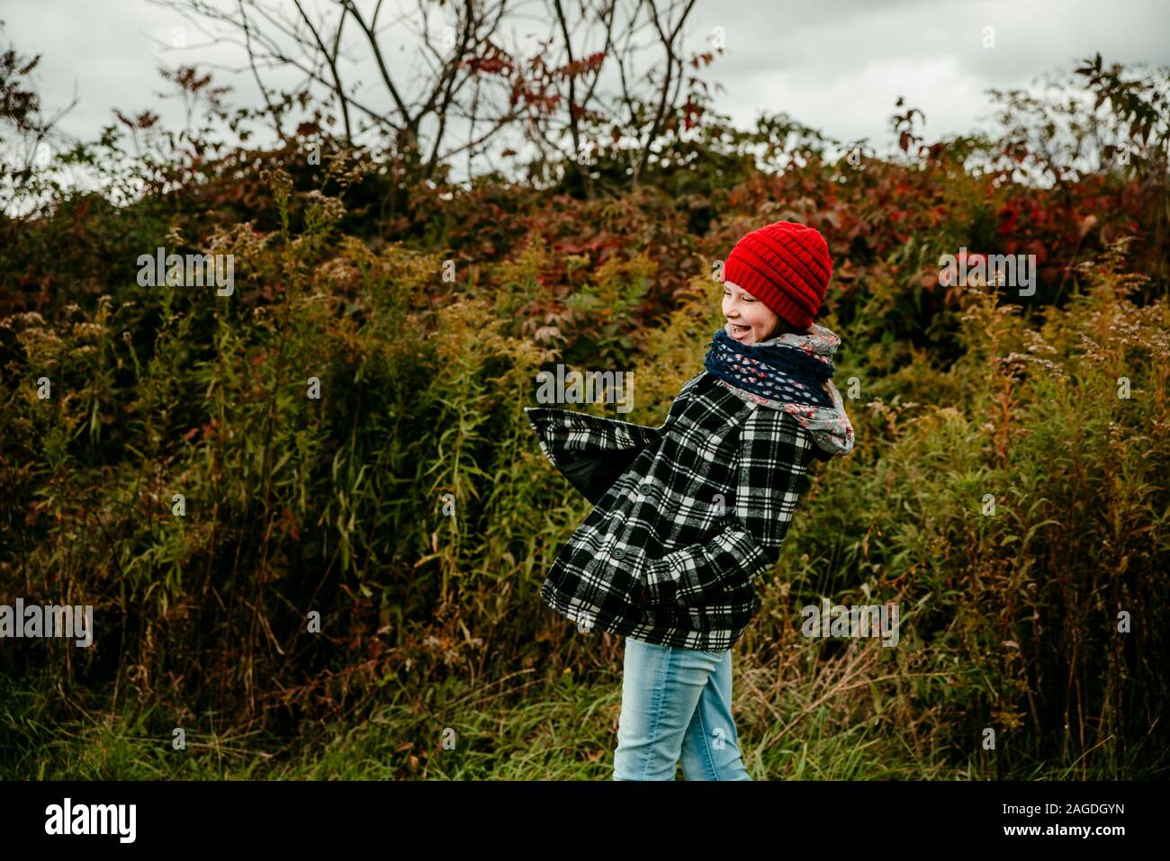 Jeune fille rire et jouer dans un champ en octobre au Michigan Banque D'Images