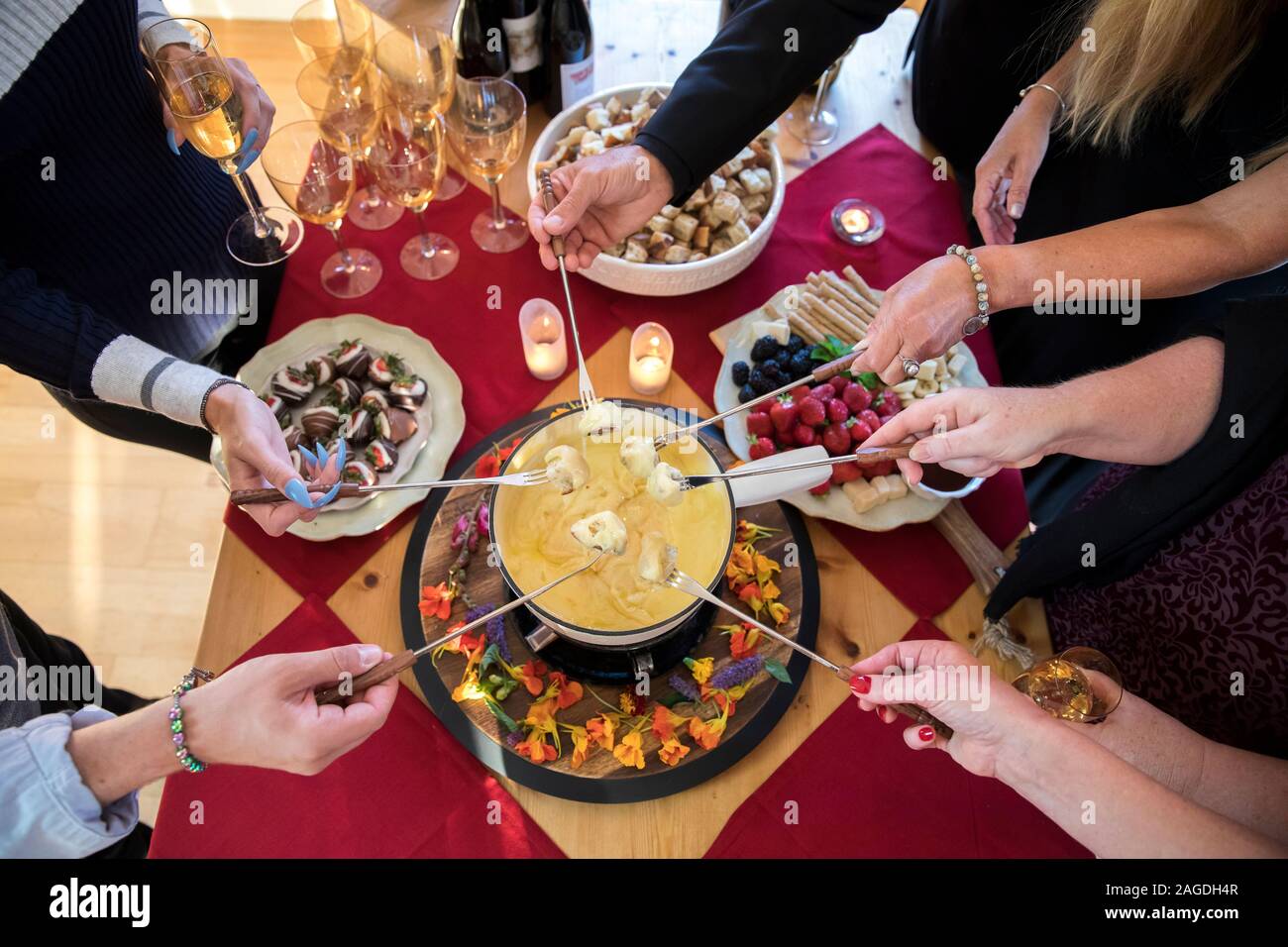 Vue de dessus de mains trempant le pain dans la fondue au fromage Banque D'Images