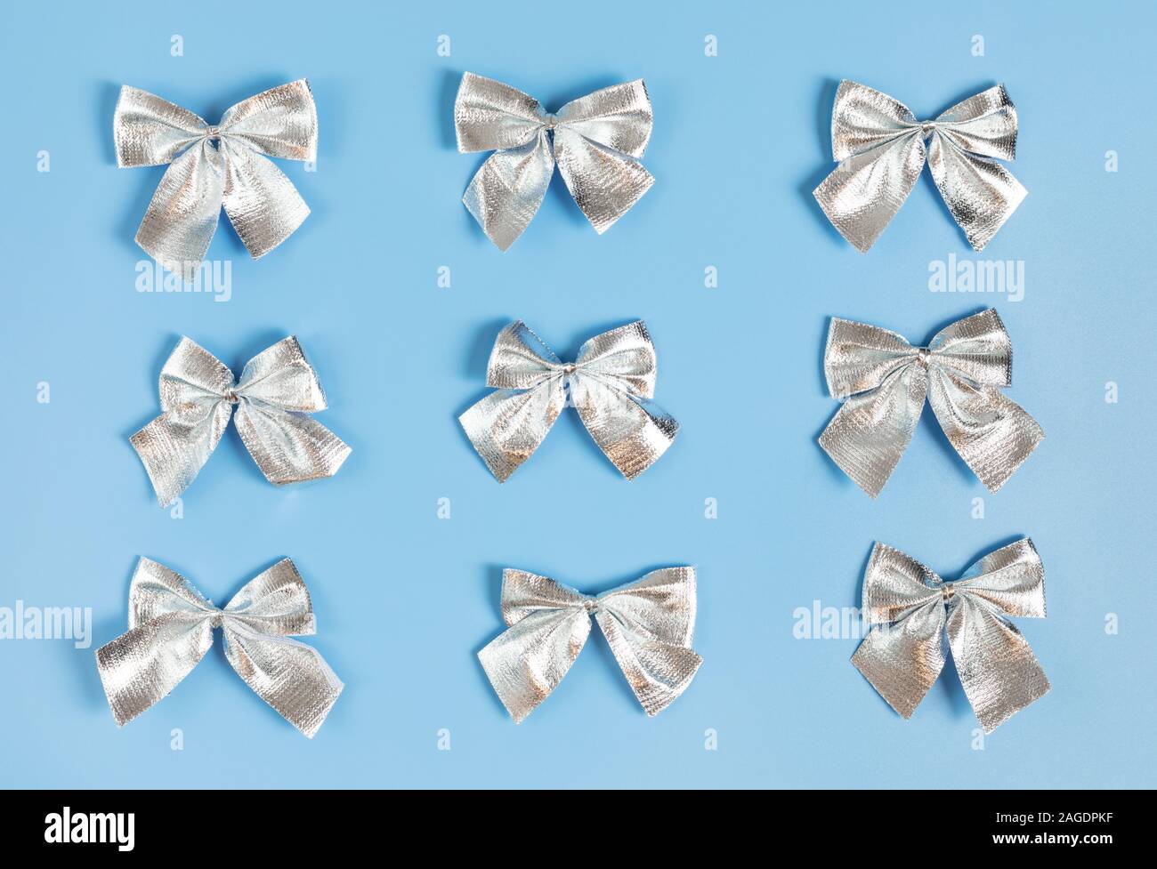 Motif de Noël avec des arcs d'argent sur fond bleu pastel. Bonne année. Concept d'hiver. Carte de vœux. Haut de la vue, télévision lay. Banque D'Images