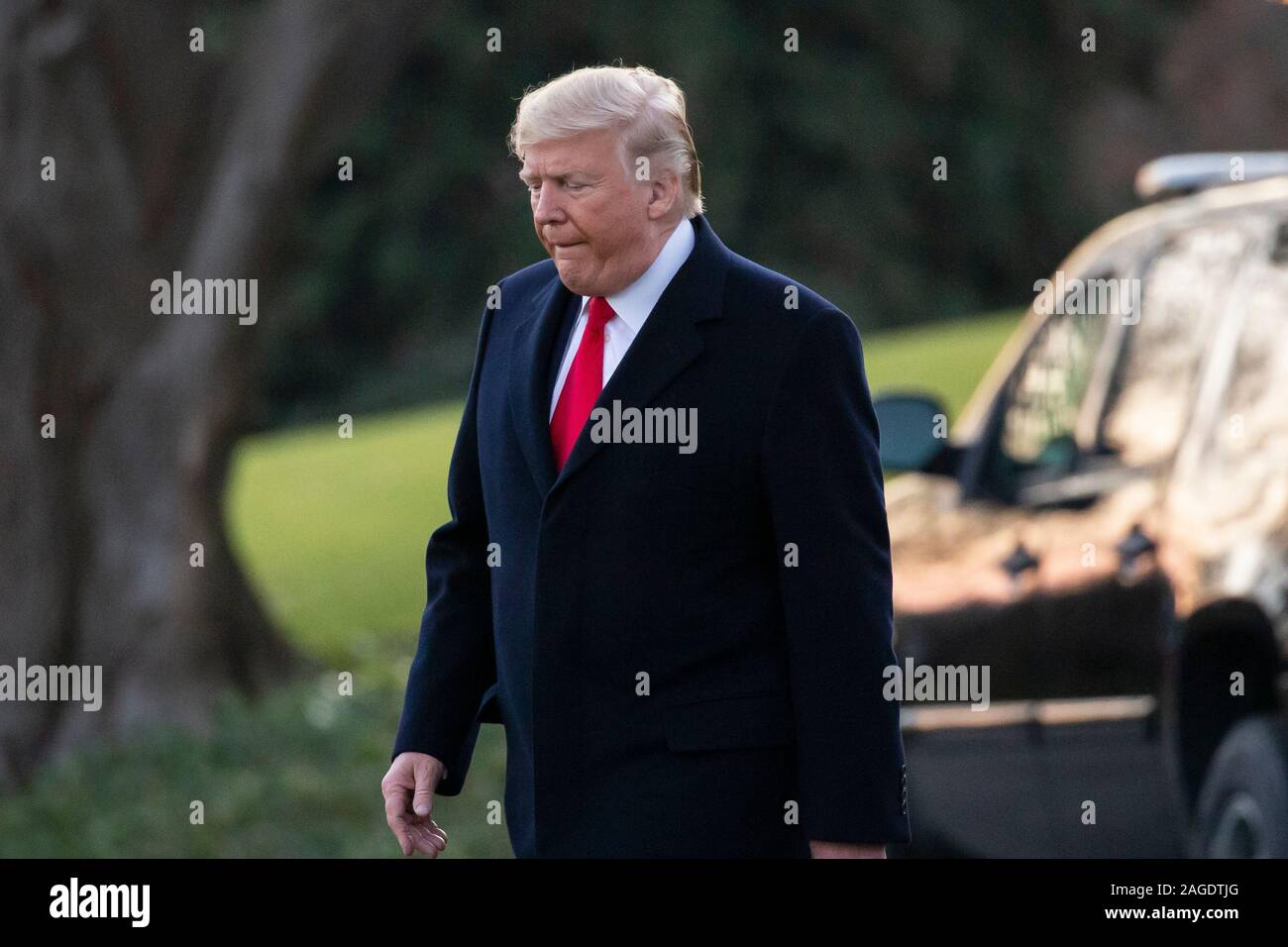 Le président américain, Donald J. Trump marche à travers la pelouse Sud de la Maison blanche avant le départ par un marin en route vers le Michigan pour un rassemblement, à Washington, DC, USA, 18 décembre 2019. La Chambre des représentants des États-Unis s'apprête à voter sur deux articles de destitution contre le président américain, Donald J. Trump, d'abus de pouvoir et de l'obstruction du Congrès. Si elle est adoptée, serait l'Atout devenir le troisième président des Etats-Unis, de l'histoire à être destitué. Une mise en accusation entraînerait un procès au Sénat des États-Unis, où un vote des deux tiers de l'approbation serait nécessaire afin de retirer en tant que président d'Atout.Crédit : Michael Reyno Banque D'Images