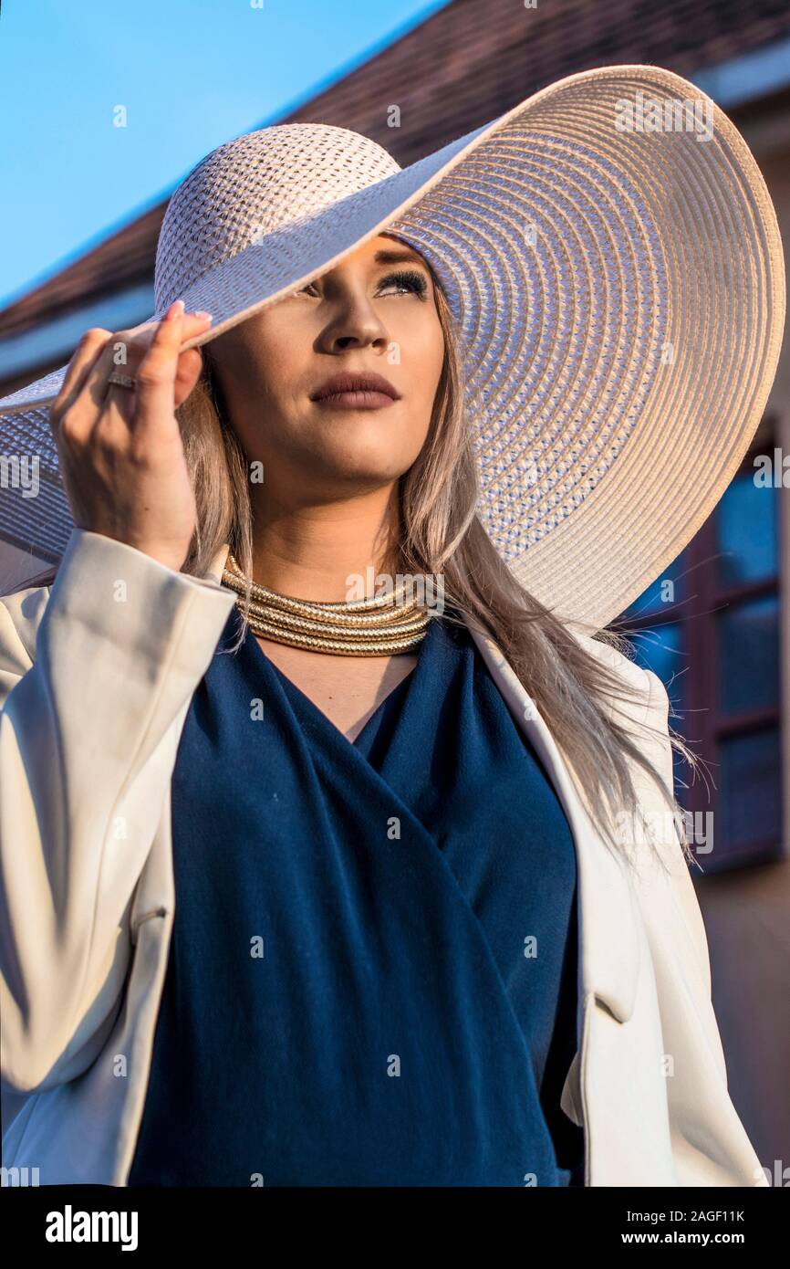 Belle femme dans un grand chapeau blanc à côté de la Photo Stock - Alamy