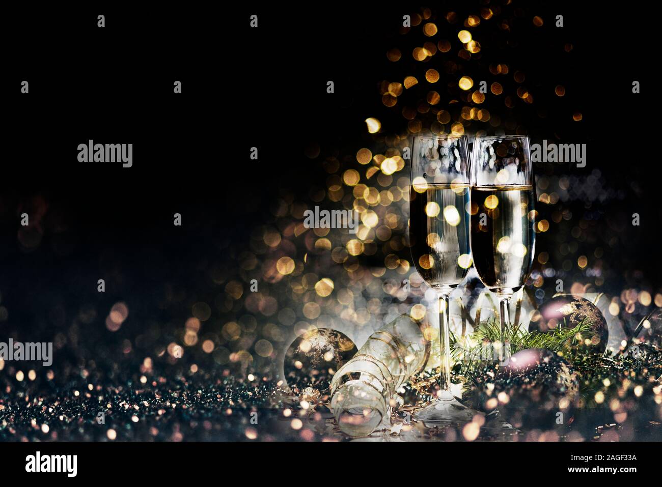 Deux verres de champagne et décoration de Noël sur fond d'Or foncé effet bokeh. Nouvel an et célébration de Noël parti de luxe. Nouvelle année Banque D'Images