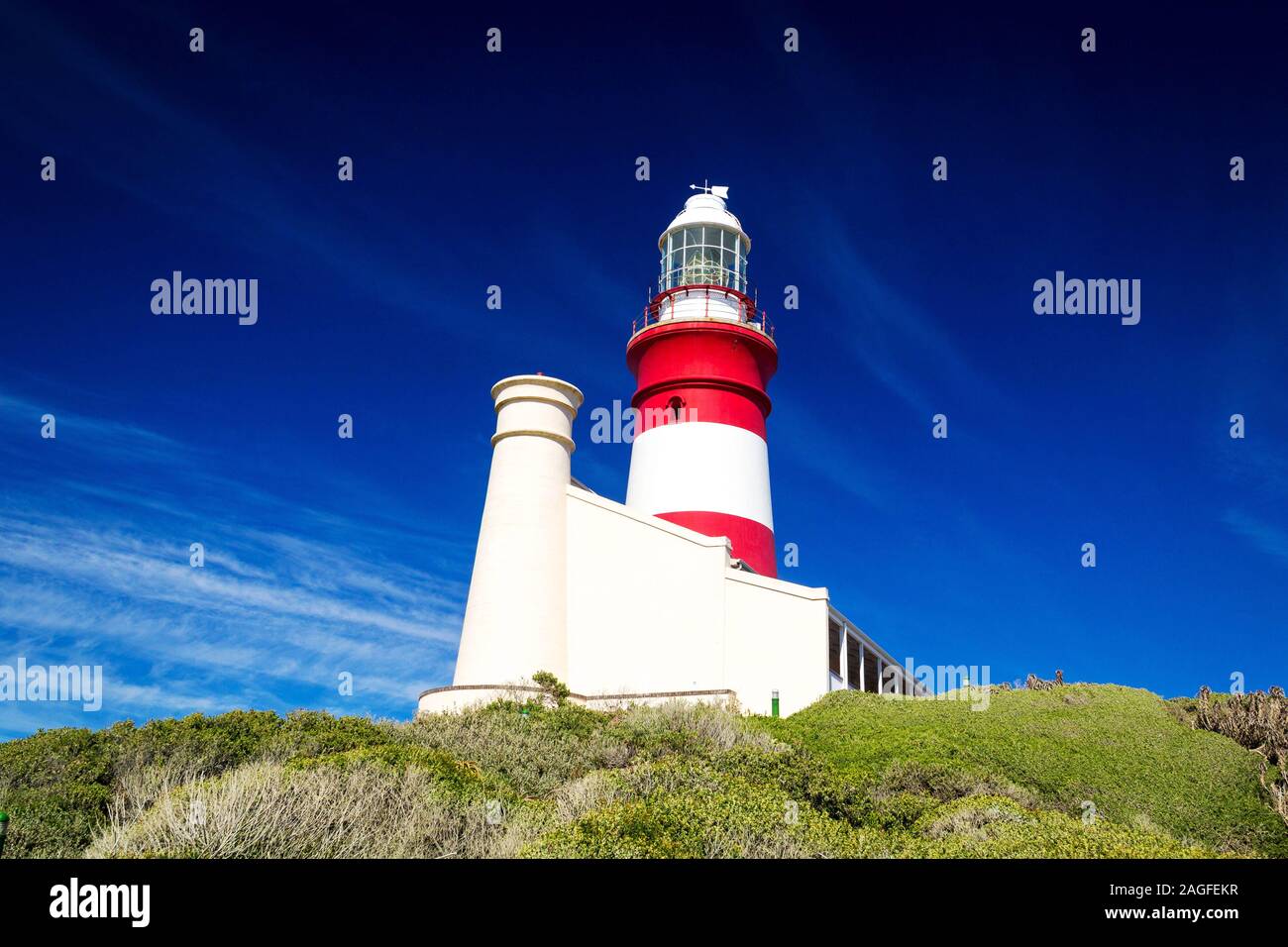 Le rouge et blanc phare à cap Agulhas lors d'une journée ensoleillée avec ciel bleu clair, Afrique du Sud Banque D'Images
