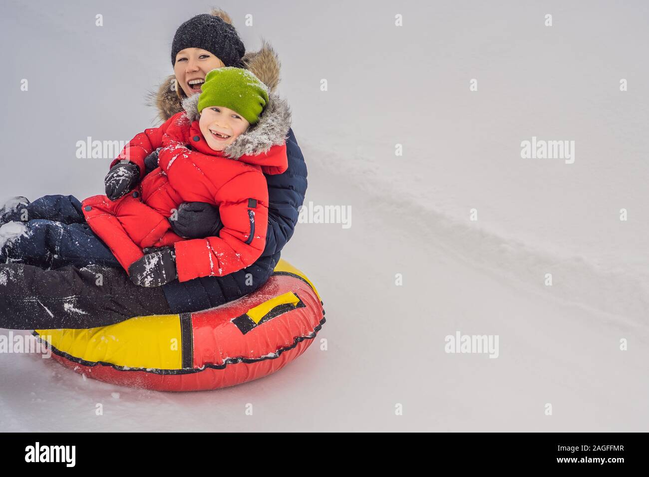 Maman fils monter sur une luge hiver gonflable tube. Plaisir d'hiver pour  toute la famille Photo Stock - Alamy