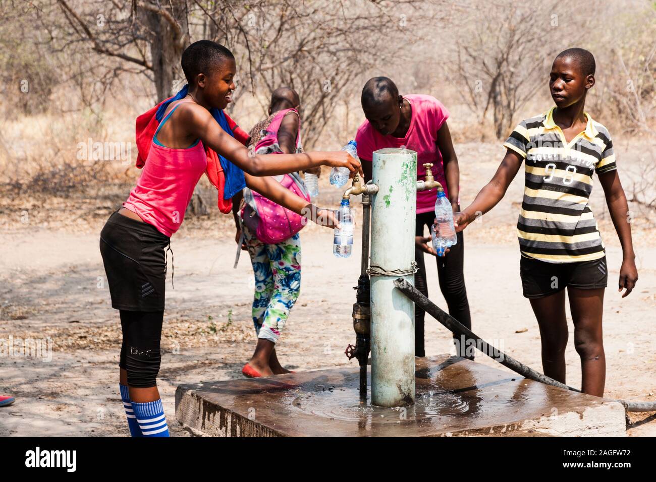 Sites d'art rupestre des collines de Tsodilo, étudiants locaux en visite, puits d'eau sur le site du camp, dans le désert de kalahari, Botswana, Afrique australe, Afrique Banque D'Images