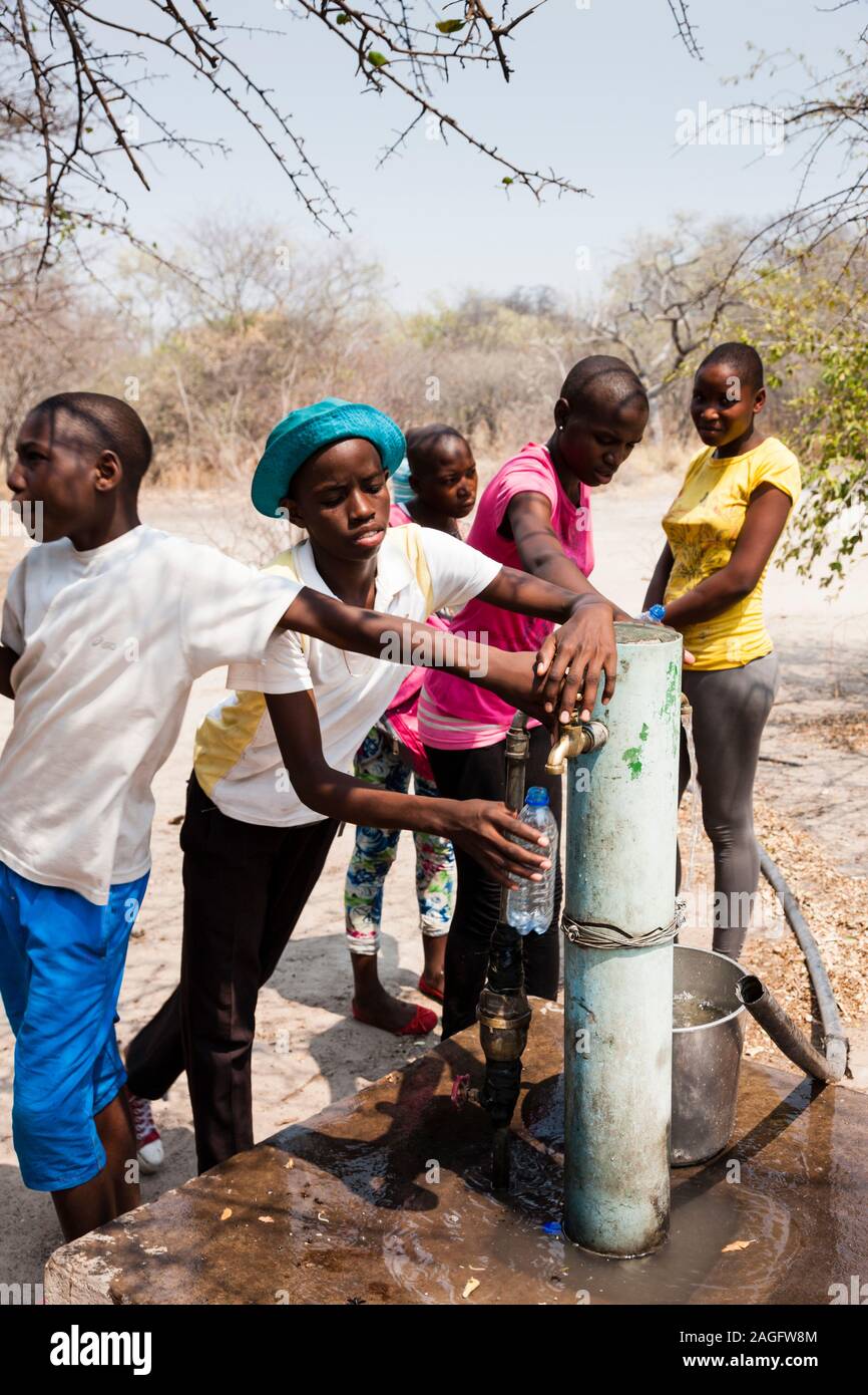 Sites d'art rupestre des collines de Tsodilo, étudiants locaux en visite, puits d'eau sur le site du camp, dans le désert de kalahari, Botswana, Afrique australe, Afrique Banque D'Images