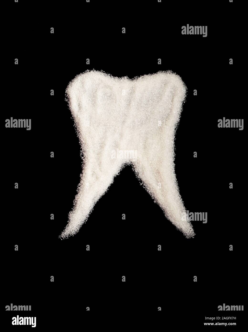 Dent blanche faite de sucre sur un fond noir. Le sucre raffiné, illustrant une dent humaine. Le concept de la nocivité d'un aliment sucré, pour les dents, les th Banque D'Images