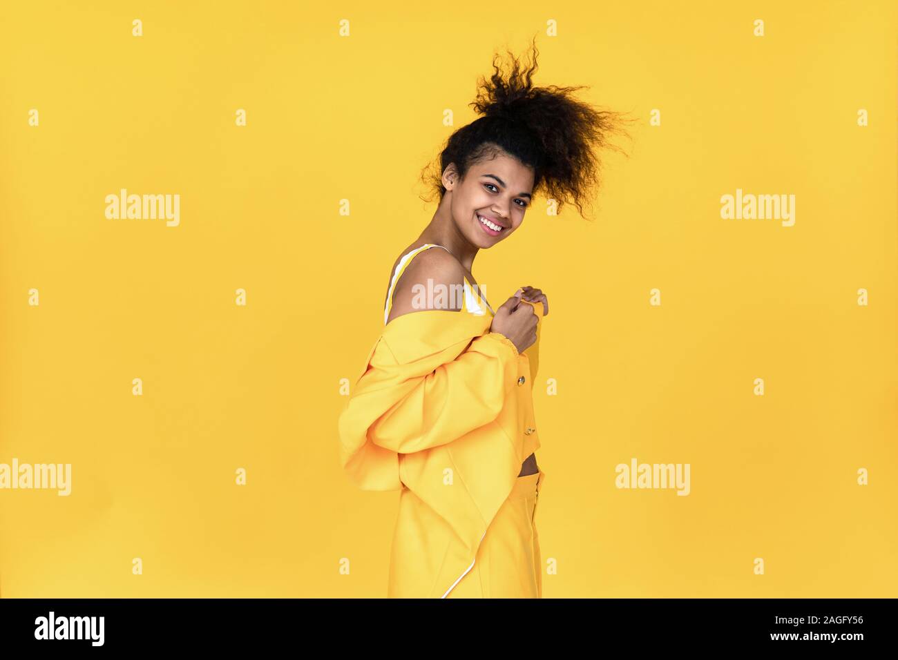 Happy fashion young African girl porter des vêtements costume jaune élégant danser s'amuser isolé sur fond, smiling mixed race woman position sur su Banque D'Images