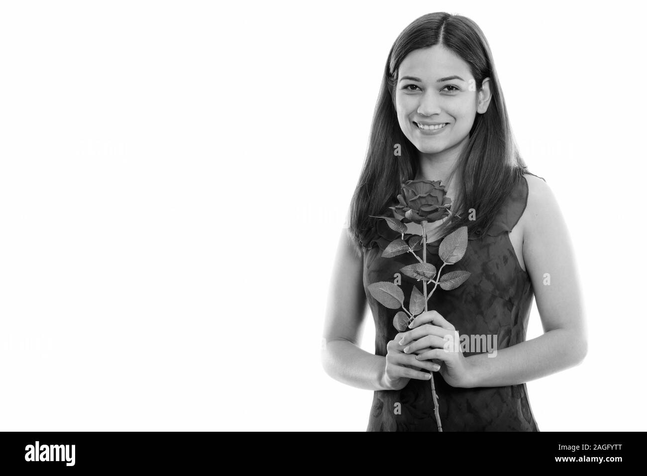 Portrait of happy young Beautiful woman smiling and holding red rose prêt pour la Saint-Valentin Banque D'Images