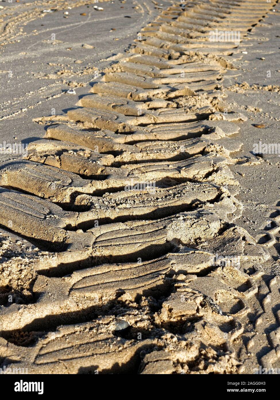 Les pistes dans le sable - Traces de pneu laissées par un tracteur de pêcheur sur une plage à Norfolk. Banque D'Images
