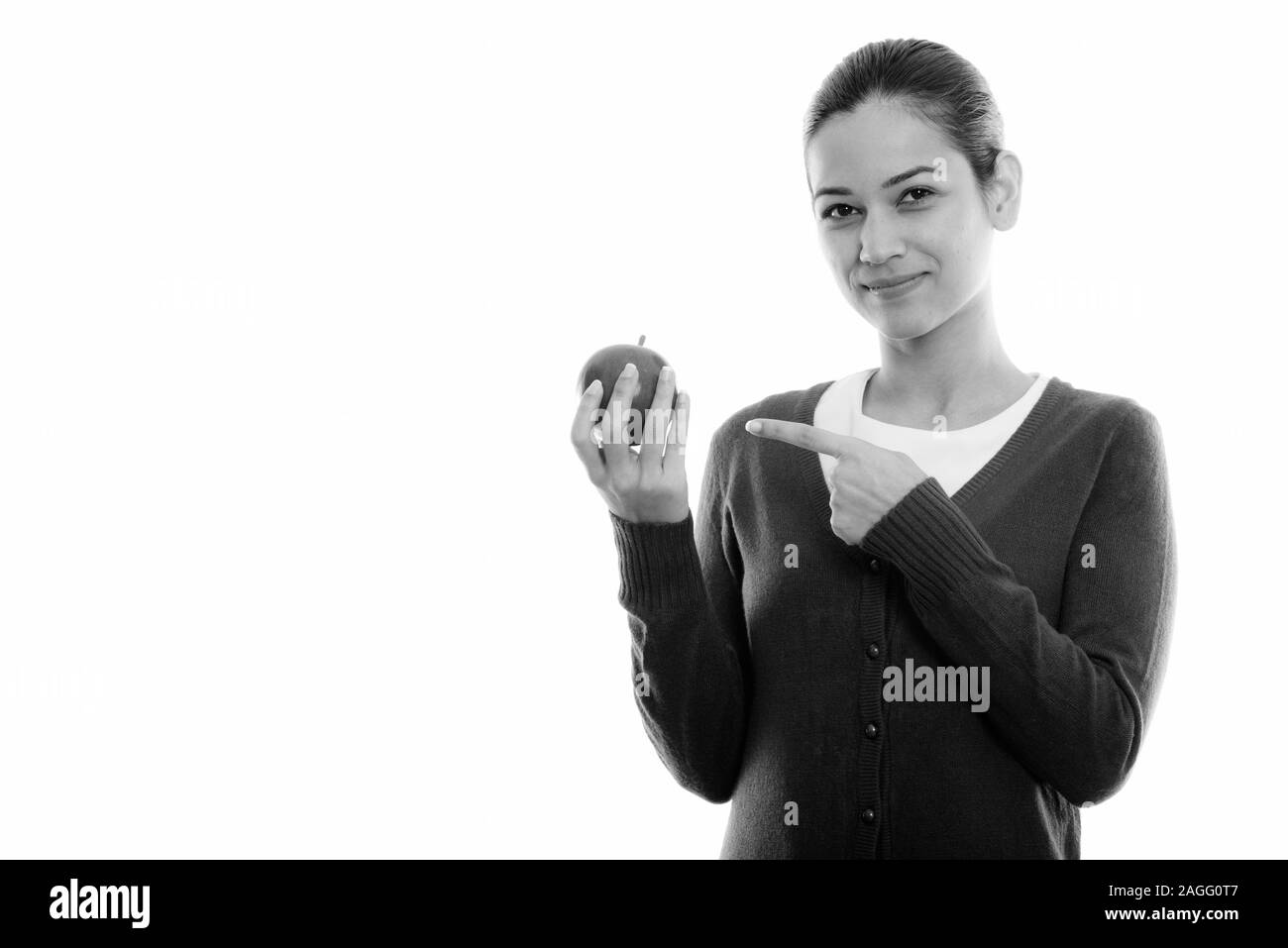 Studio shot of young Beautiful woman holding and pointing at Red Apple Banque D'Images Studio shot of young Beautiful woman holding and pointing at Red Apple Banque D'Images