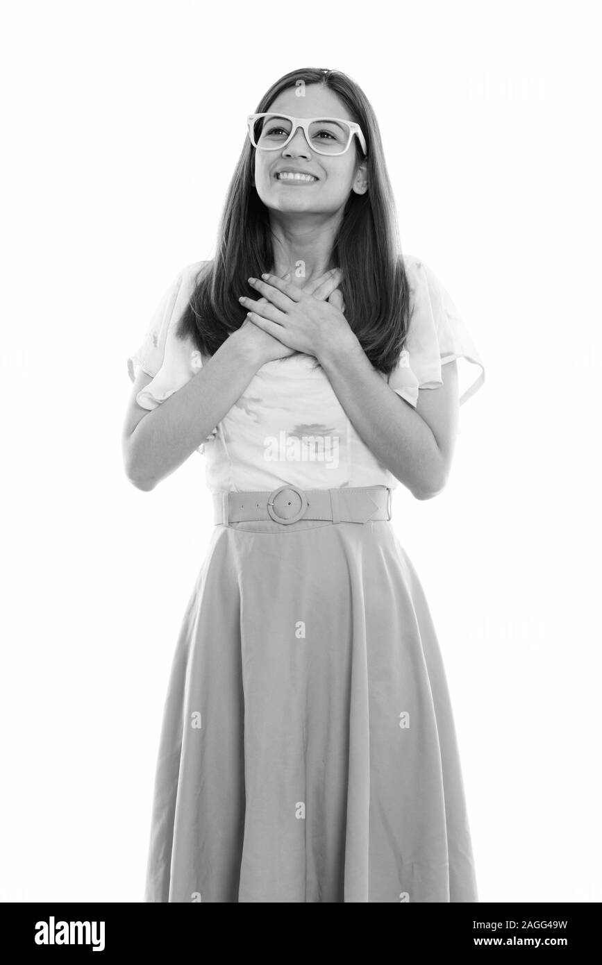 Thoughtful young woman smiling avec les mains sur la poitrine Banque D'Images