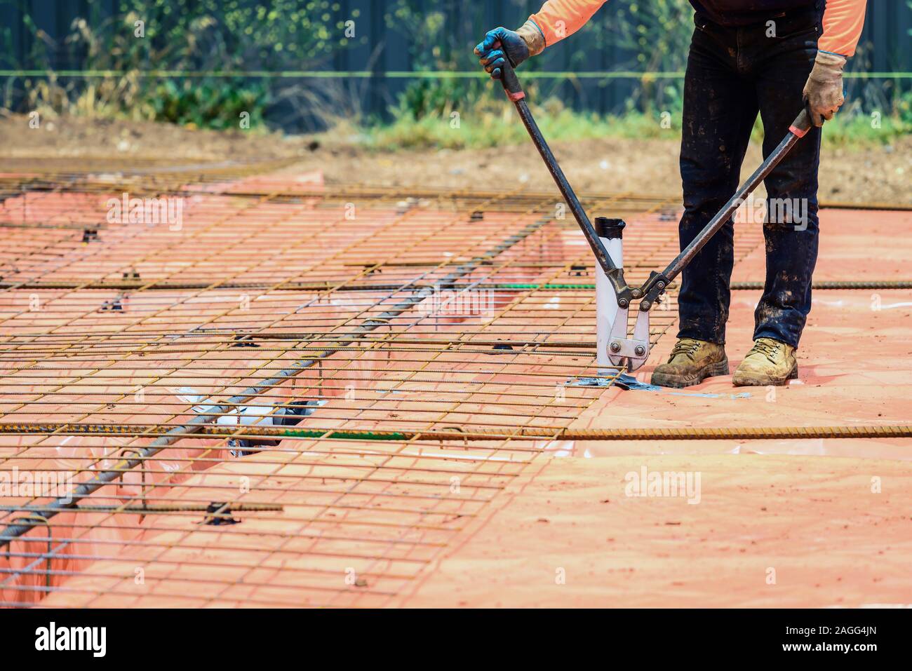 Constructeur australien avec filet coupe cutters dans le cadre de processus de fixation en acier pour une nouvelle maison de banlieue Banque D'Images