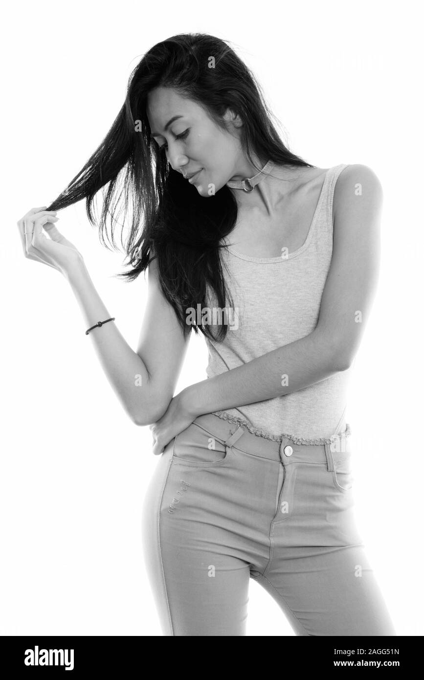 Studio shot of young woman touching belle asiatique tout en regardant ses cheveux Banque D'Images Studio shot of young woman touching belle asiatique tout en regardant ses cheveux Banque D'Images