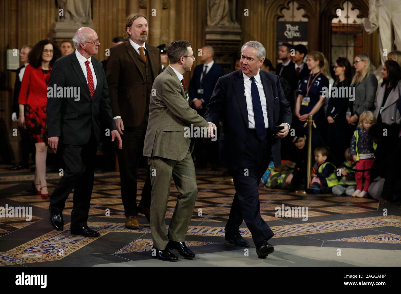 Procureur général Geoffrey Cox (à droite) serre la main avec un collègue comme il le processus à travers le hall central de la chambre des Lords à la Chambre des communes après les membres du parlement ont été convoqués pour écouter le discours de la reine lors de l'État Ouverture du Parlement par la reine Elizabeth II, à la Chambre des Lords au Palais de Westminster à Londres. Banque D'Images