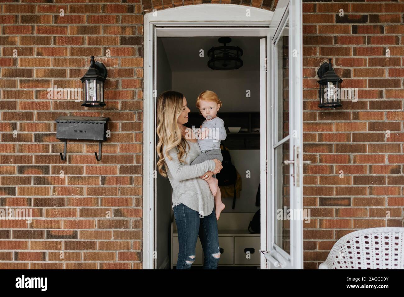 Mère avec fils à l'avant porte de chambre Banque D'Images