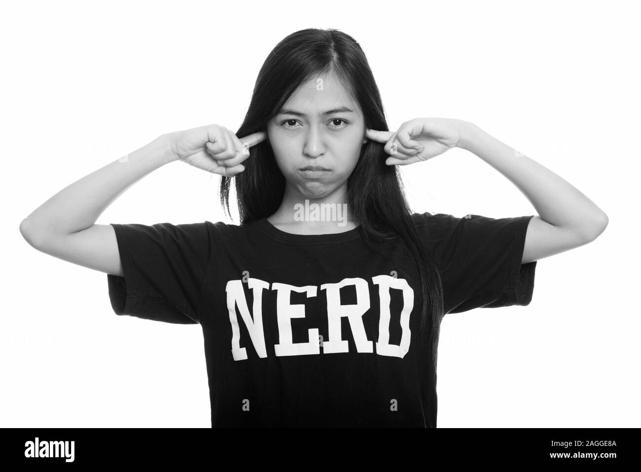 Studio shot of young Asian teenage girl nerd couvrant les oreilles avec les doigts Banque D'Images