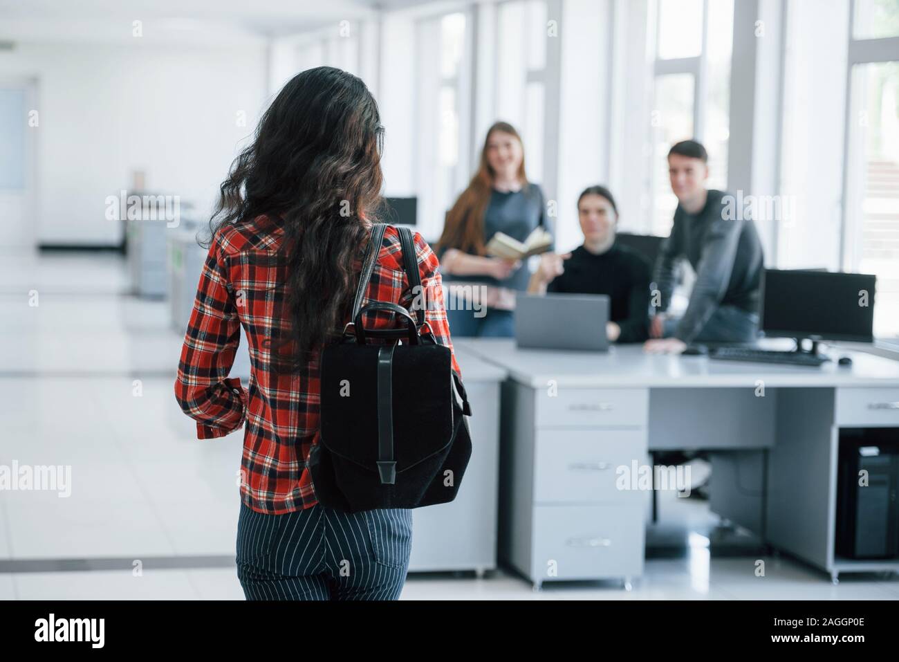 Vue depuis l'arrière. Groupe de jeunes dans les tenues de travailler dans les bureaux modernes Banque D'Images