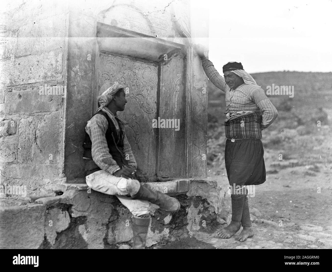 La Turquie dans la région de compatriotes Ottoman customes traditionnel dans un dialogue lors d'une 'Menzil" fontaine. Menzils ces établissements étaient situés en dehors et servi caravanes, les voyageurs, les agriculteurs et leurs animaux. Les fontaines avaient des inscriptions en vers, avec la dernière ligne qui fournit des informations concernant la date de la construction, soit directement ou en calcul Ebced exemplaire dans une plaque de verre à sec, provenant de l'Herry W. Schaefer collection. Banque D'Images