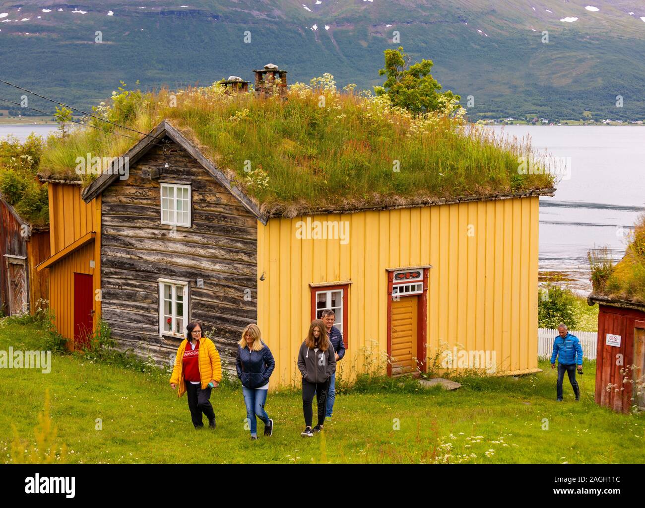 L'ÎLE DE KVALØYA, STRAUMSBUKTA, comté de Troms, NORVÈGE - Touristes au musée historique village de Straumen Gård avec toit gazon bâtiments. Toit de chaume est tradit Banque D'Images