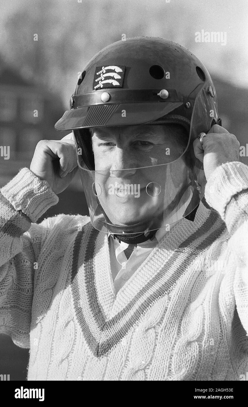 1980, cricketer essayant sur un nouveau casque de cricket avec un guide de sécurité en plastique, Angleterre, Royaume-Uni. Les chapeaux de protection du cricket n'étaient pas utilisés en commun avant la fin des années 1970 et évoluaient à mesure que le batteur cherchait à se protéger de la tête par un court bowling rapide. En 1978, Graham Yallop, d'Australie, est devenu le premier cricketeur à porter un dans un match d'essai. Banque D'Images