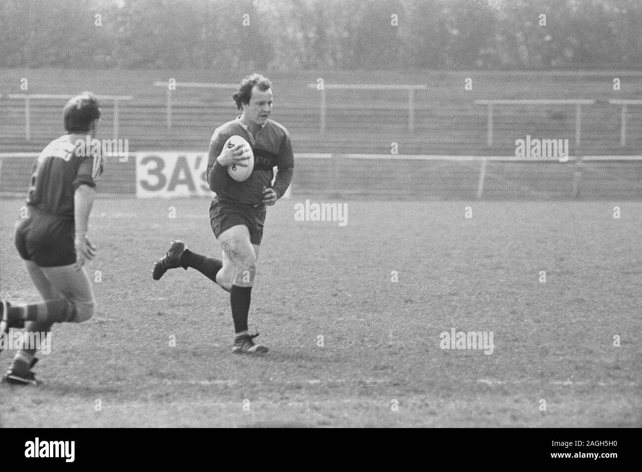 1980, un joueur de rugby masculin historique qui pratique un ballon de rugby en dehors sur un terrain, Angleterre, Royaume-Uni. Banque D'Images