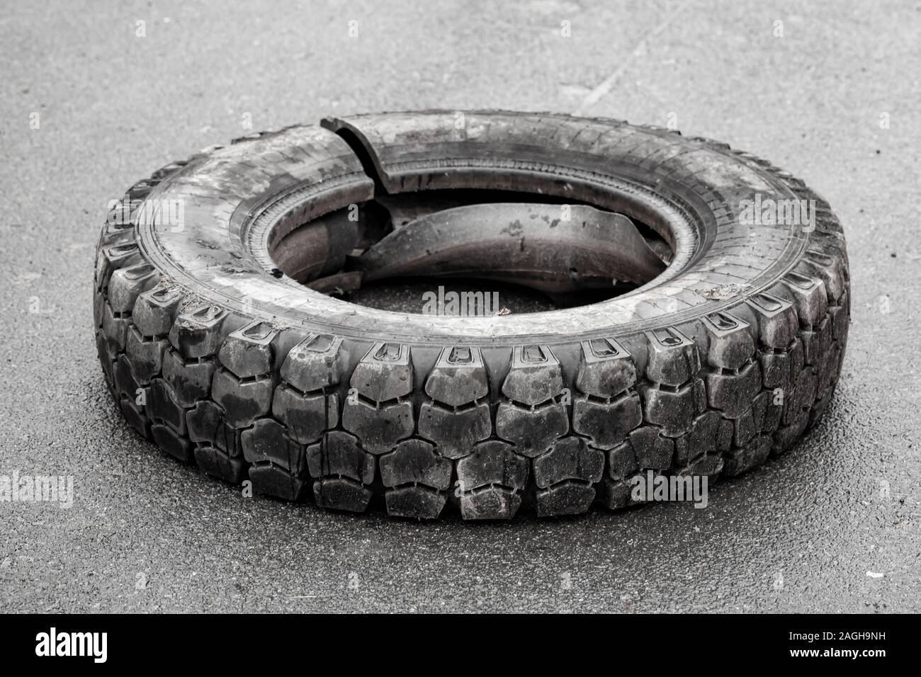 Ancien endommagé utilisé les pneus de camion se pose sur une route asphaltée Banque D'Images