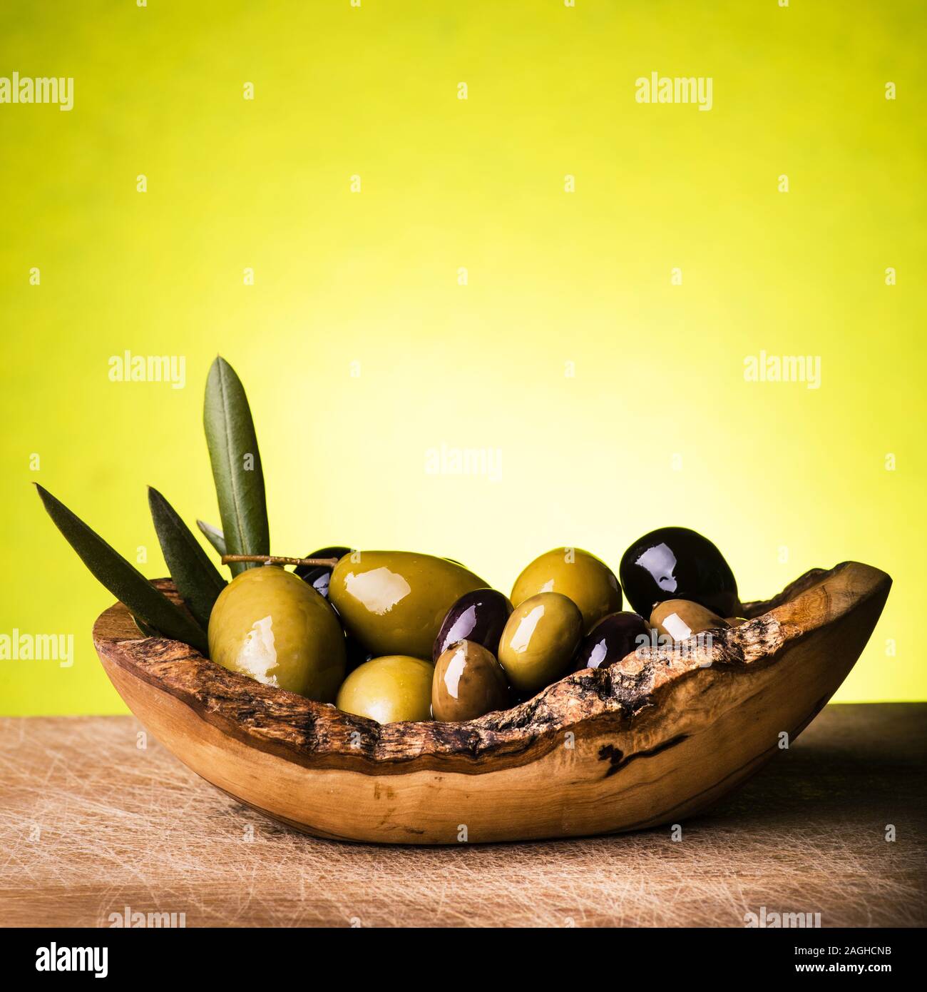Libre de divers types d'olives dans un bol en bois rustique Banque D'Images