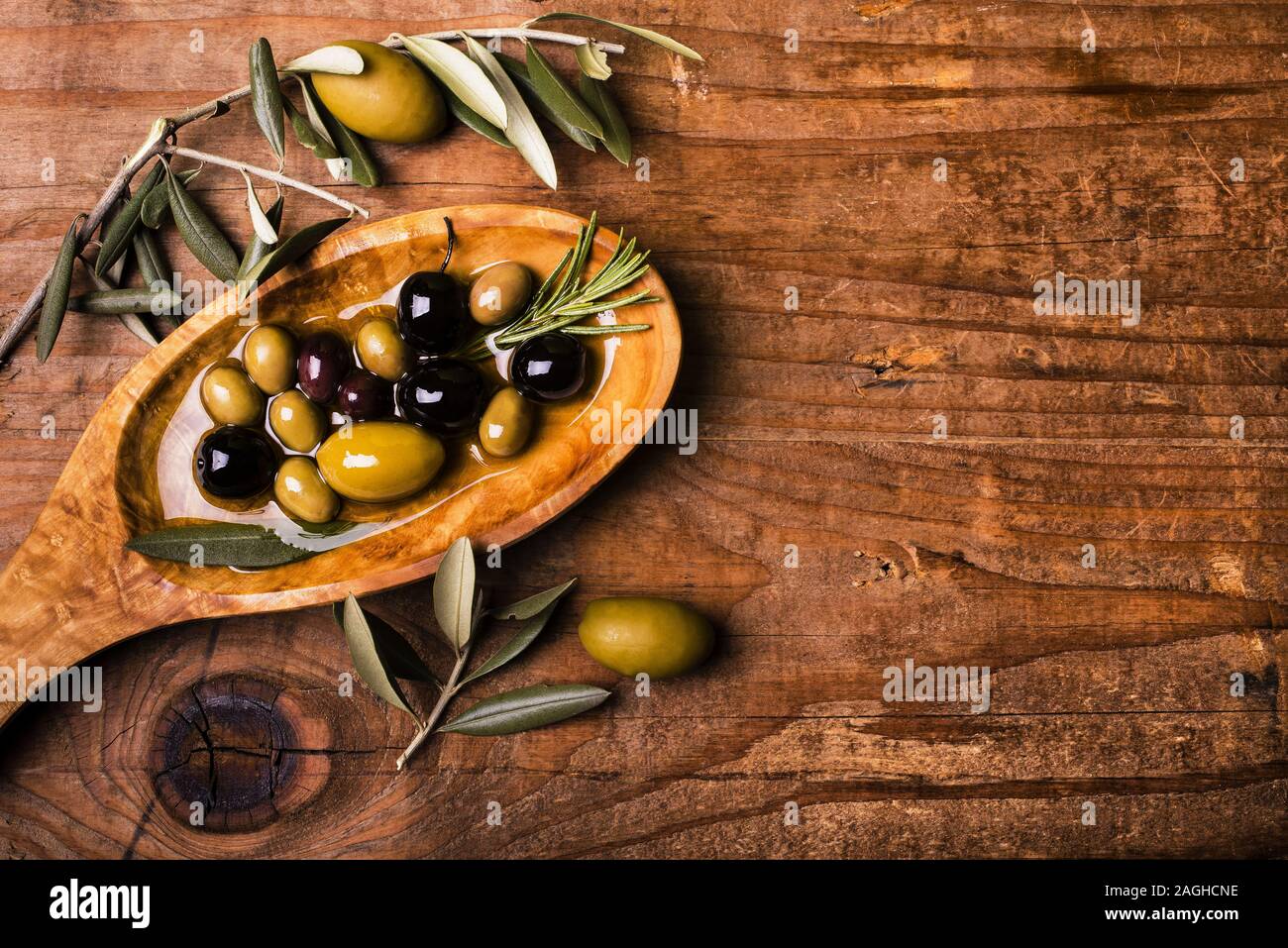 Sur la table de bois rustique, un bol avec différents types d'olives Banque D'Images