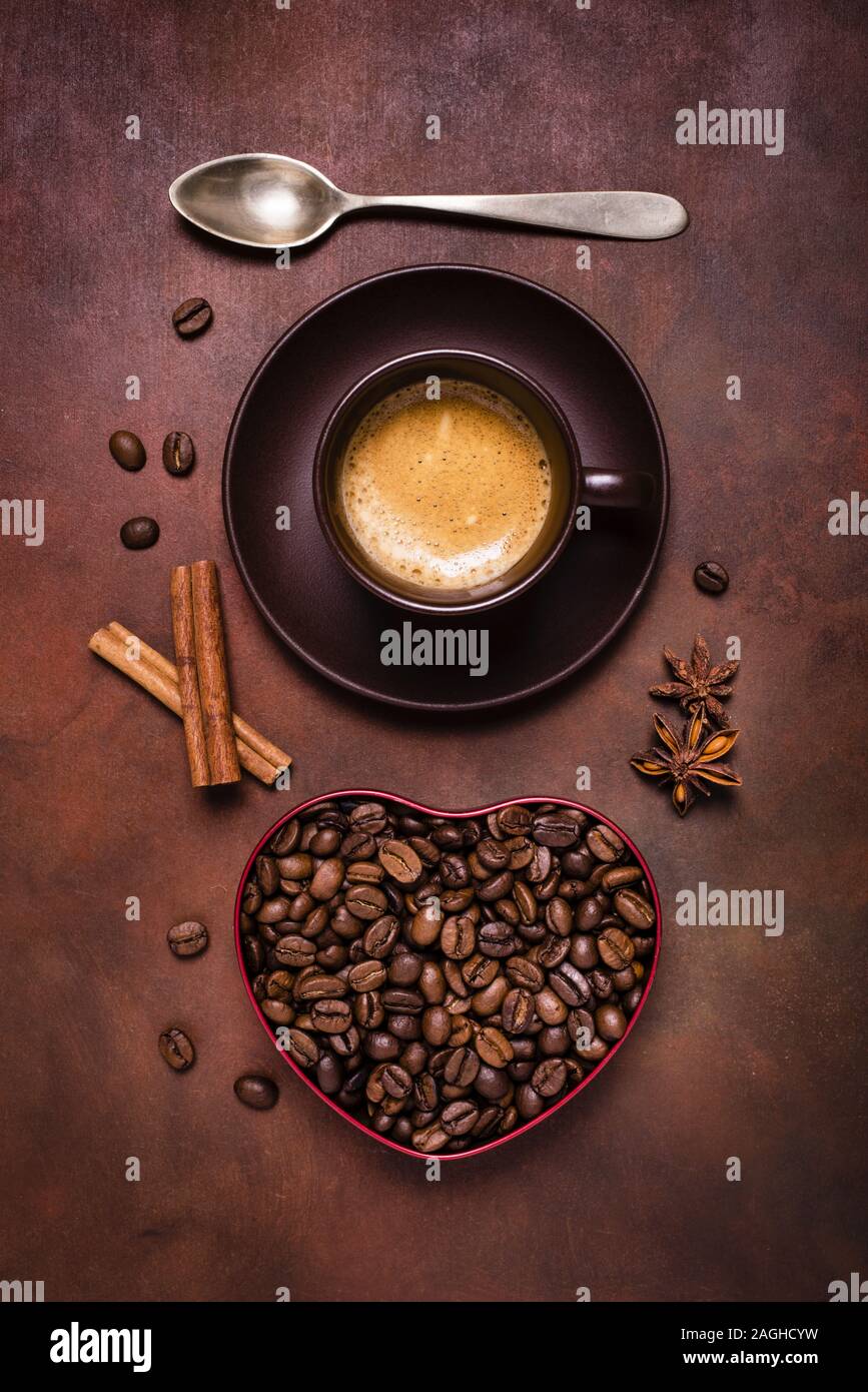 La composition avec une tasse de café, et un bol en forme de coeur avec les grains de café Banque D'Images