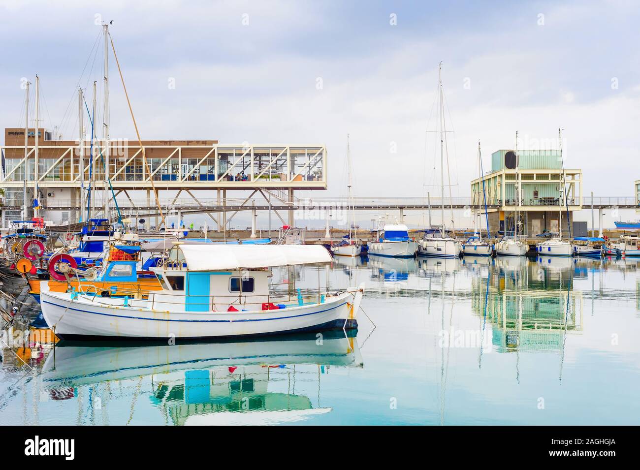 La ville de Limassol, vue sur le port de pêche amarrés les bateaux à moteur, des restaurants sur la jetée sous un ciel avec des nuages de pluie, Chypre Banque D'Images