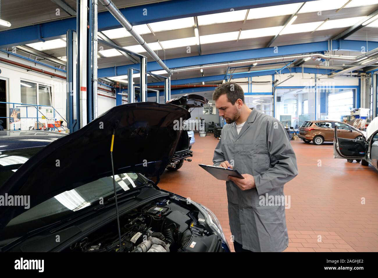 Mécanicien dans un atelier vérifie et inspecte un véhicule pour les défauts Banque D'Images