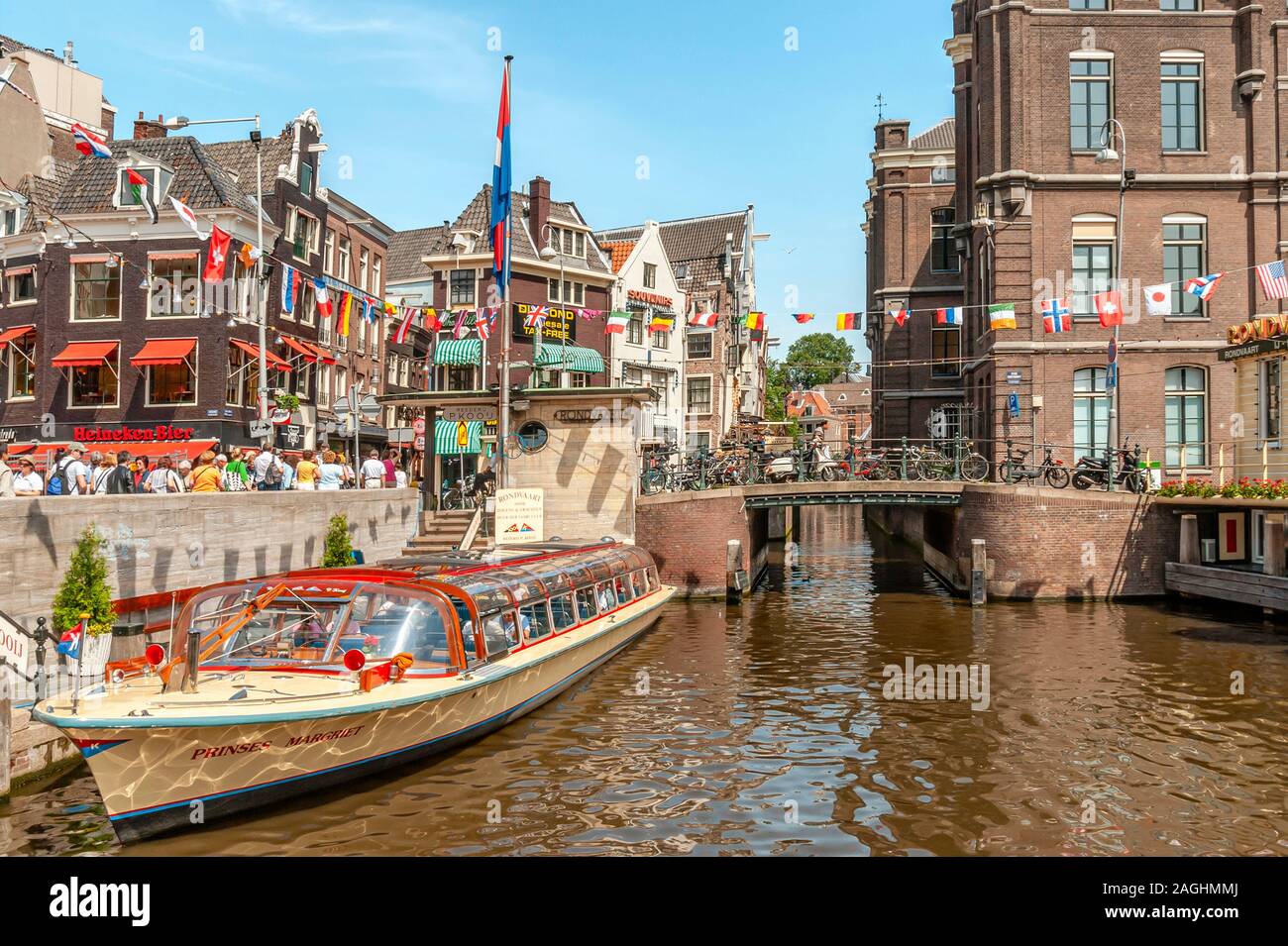 Des bateaux touristiques dans un canal d'eau dans le centre-ville d'Amsterdam, Pays-Bas. Banque D'Images