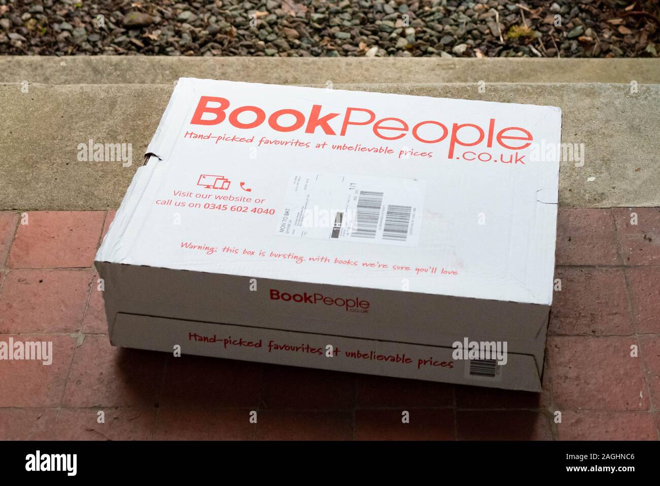 Les gens du livre porte sur le colis l'adresse de livraison (supprimé) - UK Banque D'Images