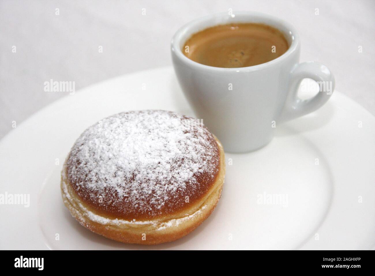 Des beignets de carnaval autrichien appelé Faschingskrapfen ou Berliner Krapfen sucrés, remplis de confiture d'abricot et de sucre glace, espresso Banque D'Images