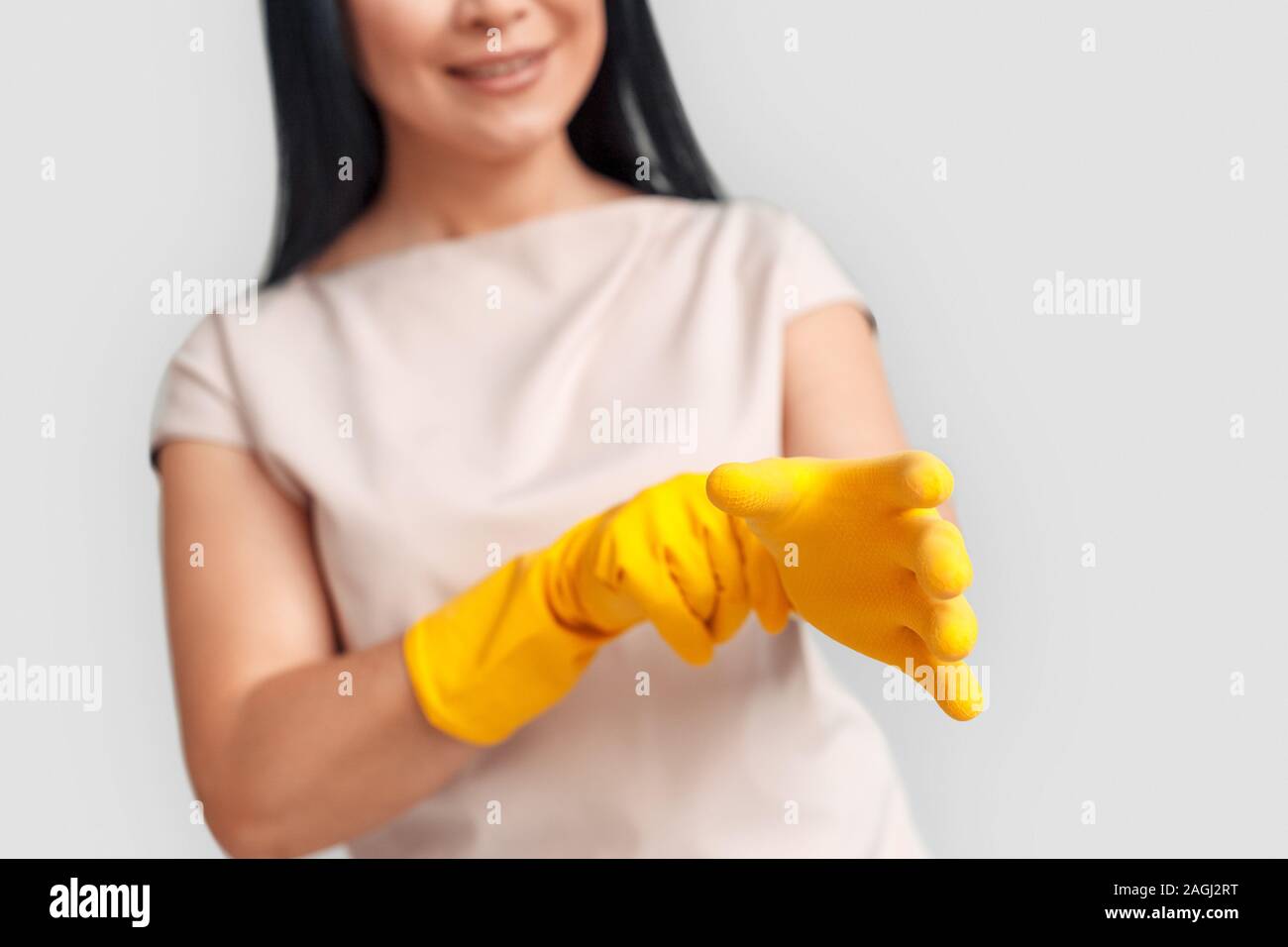 Freestyle. Asian woman putting des gants isolés sur fond blanc close-up smiling happy trouble Banque D'Images