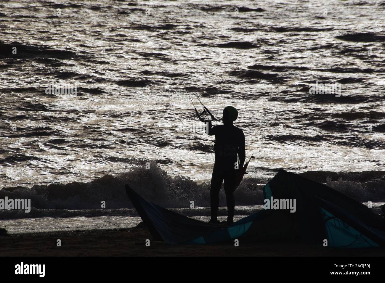 Kitesurf Exmouth, Kitesurfer découpé sur la mer argentée sur une journée l'hiver. Devon, UK Banque D'Images