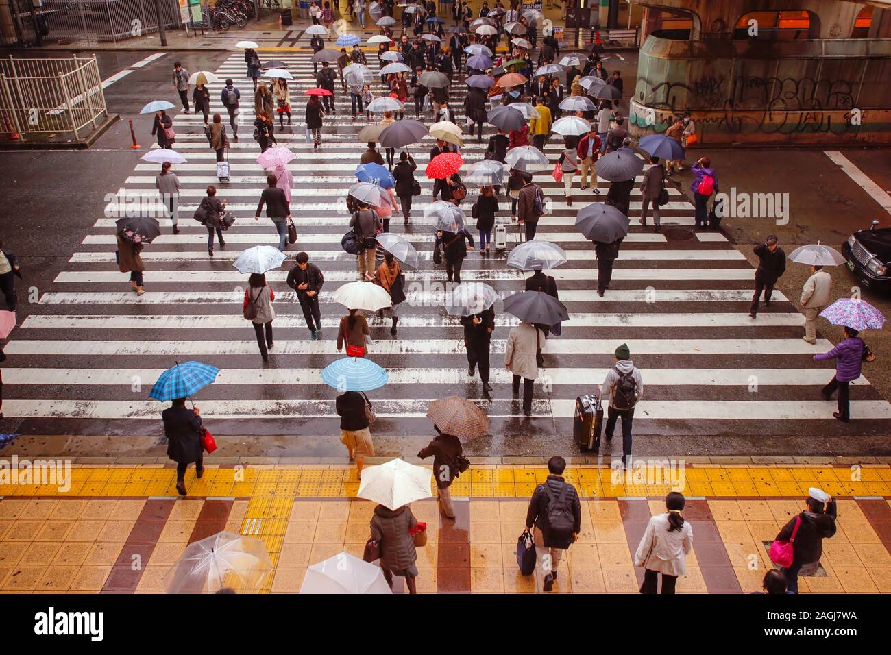 TOKYO, JAPON - 25 NOVEMBRE 2014 : Les gens de marcher sous la pluie dans un passage pour piétons à Tokyo, Japon. Banque D'Images