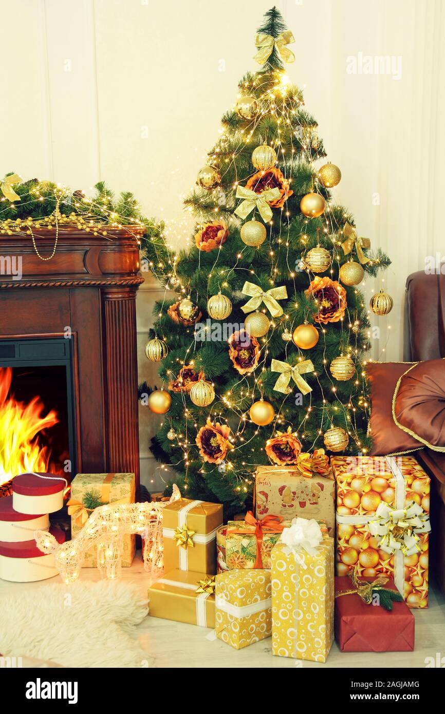 Sapin de noël, arbre de Noël et cadeaux décorations d'or près de cheminée. Nouvelle année. Noël. Banque D'Images